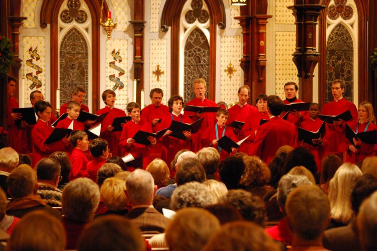 Group performing in the church with red robes.
