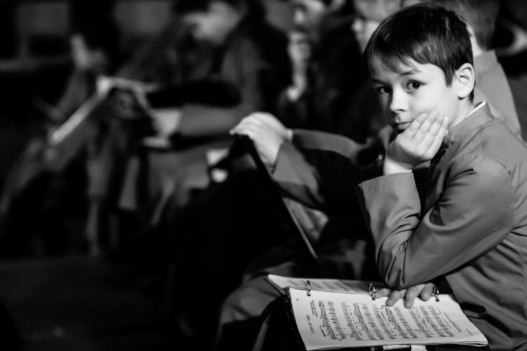 Young chorister sitting with open music folder