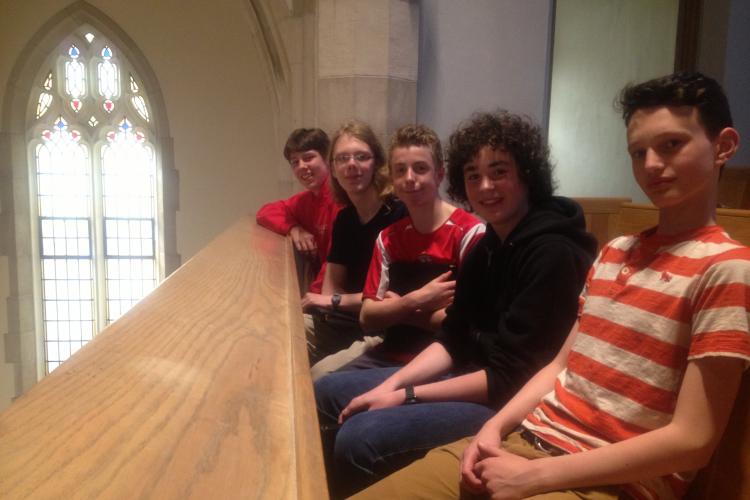 Young Men sitting in a row in a church balcony pew