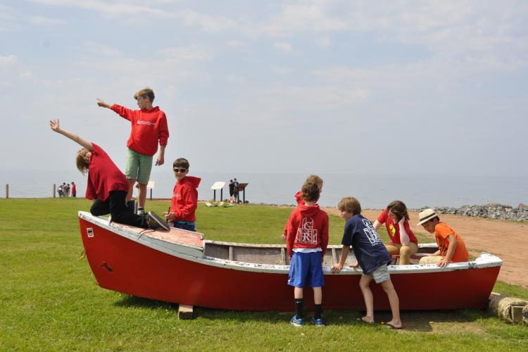 Boy choristers playing on a Nova Scotia dory boat