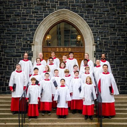Group photo of choir in robes on Cathedral steps